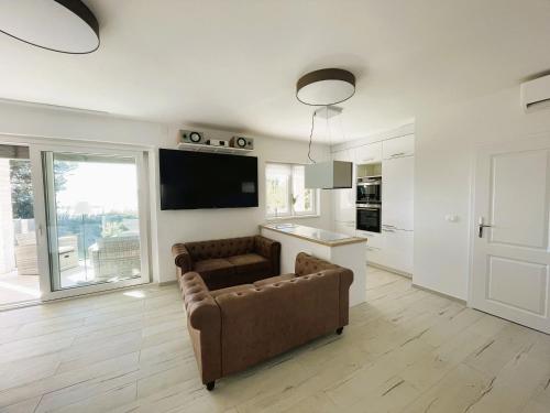 un salon avec un canapé et une télévision et une cuisine dans l'établissement Villa Dobri Dupin, à Posedarje