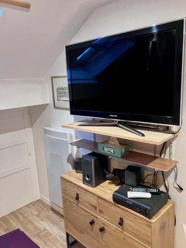 a flat screen tv sitting on a wooden stand at Camera et Caetera Chambres d'hôtes B&B in Roubaix
