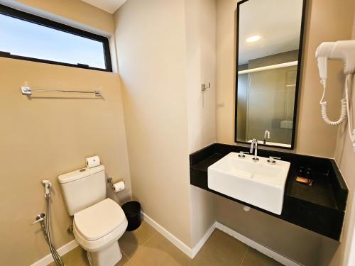 a bathroom with a white toilet and a sink at Bewiki in Florianópolis