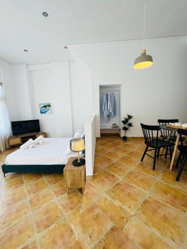 a bedroom with a bed and a table and chairs at Ammoudeli Apartments in Plomarion