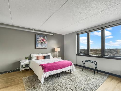 1 dormitorio con 1 cama en una habitación con ventanas en Modern Studio - Walk To Wells Fargo Arena, en Des Moines