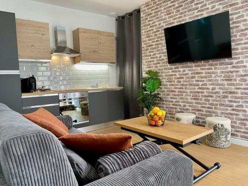 sala de estar con sofá y mesa en Les Logis d'Esmeralda-Des appartements au charme intemporel, en Romorantin-Lanthenay