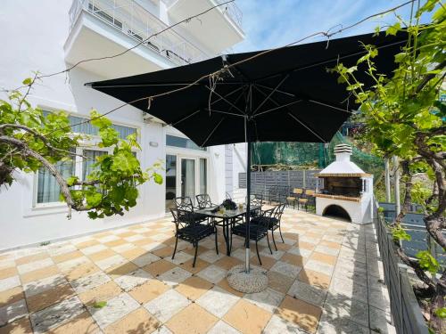 a table and chairs with an umbrella on a patio at Ammoudeli Apartments in Plomarion