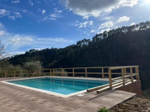 uma piscina num deque com uma montanha ao fundo em Podere il Glicine Wellness Charme & Relax em Fresonara