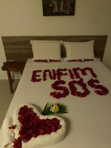 a bed with a heart made out of flowers at Pousada Águas de Tamandaré in Tamandaré