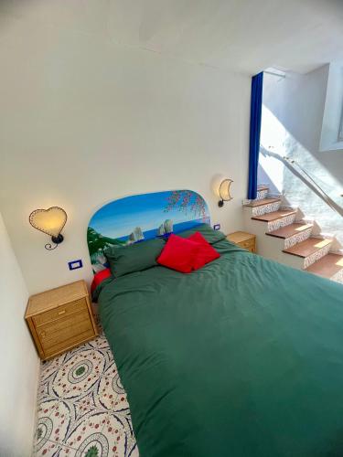a bedroom with a bed with a green comforter and stairs at La Cuchina in Capri
