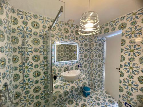 bagno con doccia, lavandino e specchio di La Cuchina a Capri