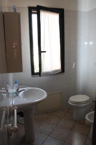 La salle de bains est pourvue d'un lavabo, de toilettes et d'une fenêtre. dans l'établissement Casa di Nanni, à Villasimius