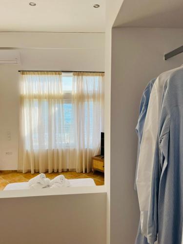 a room with a window and a shelf with clothes at Ammoudeli Apartments in Plomarion