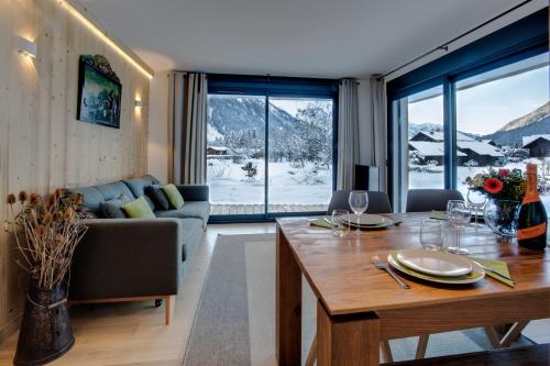 un salon avec une table et un canapé dans l'établissement La Belle Cordee SPA lujo y piscina CHAMONIX, à Chamonix-Mont-Blanc