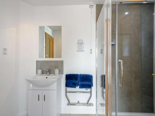 a bathroom with a sink and a shower with blue towels at 1 Bed in Attleborough 86671 in Caston