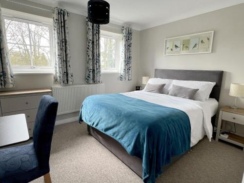sypialnia z dużym łóżkiem i niebieskim kocem w obiekcie River Rose w mieście Fakenham