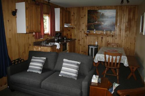 a living room with a couch and a table at Auberge et Chalets sur le Lac in Lac-Mégantic