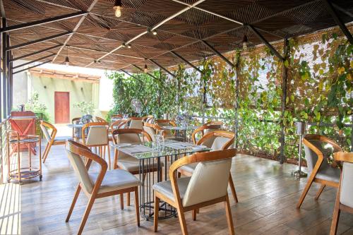 um restaurante com mesas, cadeiras e plantas em Seahorse Hotel & Spa em Negombo