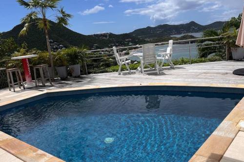 a swimming pool with two chairs and a table at Maison des Brin - Lorient Camaruche in Quartier de Lorient