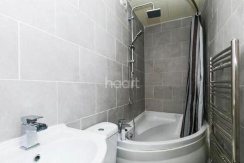 ein Badezimmer mit einem Waschbecken, einem WC und einer Badewanne in der Unterkunft 1 bedroom ground floor flat in Greenford