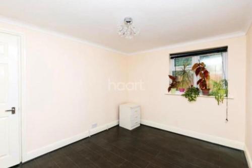 ein leeres Wohnzimmer mit weißen Wänden und einem Fenster in der Unterkunft 1 bedroom ground floor flat in Greenford
