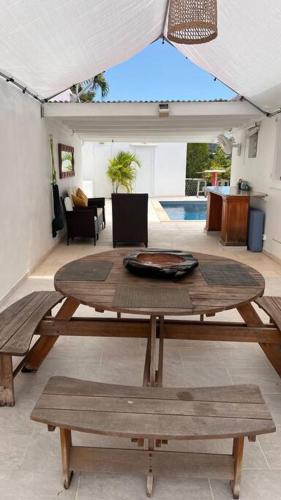 a wooden table and benches in a living room at Maison des Brin - Lorient Camaruche in Quartier de Lorient