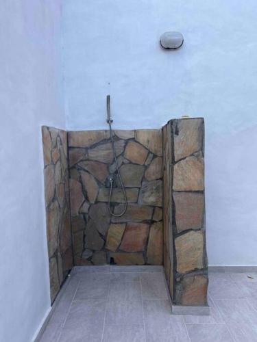 a bathroom with a stone shower with a hose at Maison des Brin - Lorient Camaruche in Quartier de Lorient