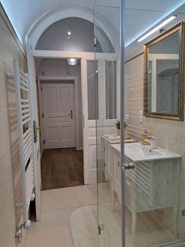 a bathroom with two sinks and a glass shower at Bem Villa Apartman, Kőszeg in Kőszeg