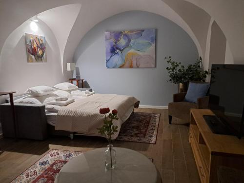 een slaapkamer met een bed en een tafel en een televisie bij Bem Villa Apartman, Kőszeg in Kőszeg