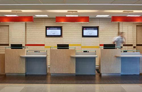 a person walking in an office lobby with desks at Ibis Cancun Centro in Cancún