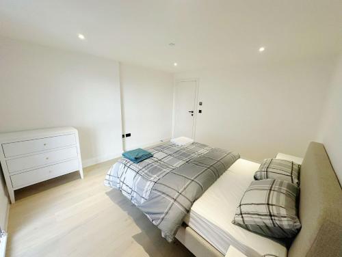 a bedroom with a bed and a dresser in it at Luxury Modern Flat Near Center in London