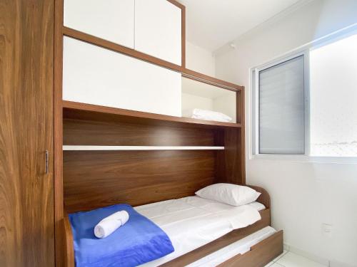 Dormitorio pequeño con cama con cabecero de madera en Resid. Clube Mar Grosso - Laguna, en Laguna