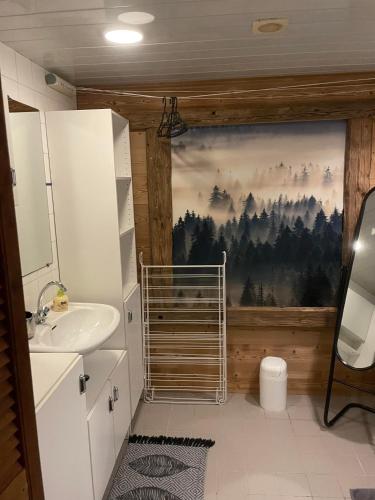 La salle de bains est pourvue d'un lavabo et d'une peinture murale. dans l'établissement Chalet 9 personnes, piscine, terrasse, à Saint-Maurice-sur-Moselle