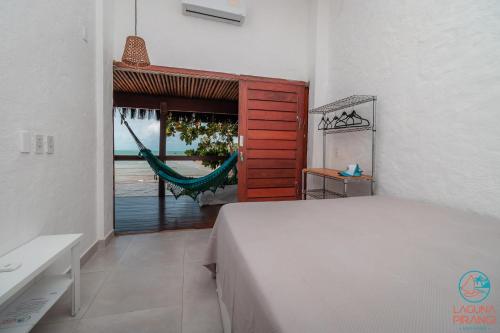 Un dormitorio con una cama y una hamaca. en Laguna Pirangi Beach House, en Parnamirim