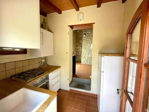 een keuken met een fornuis, een wastafel en een koelkast bij Stone house with pool in Montefiridolfi