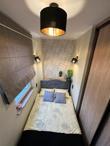 Dormitorio pequeño con cama con almohadas azules en Classy for two en Gdansk
