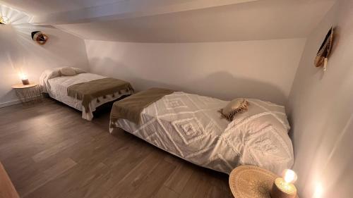 a bedroom with two beds in a room at Hôtel Résidence CAPENSE in Centuri