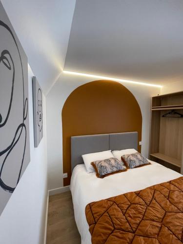 - une chambre avec un grand lit et une arche au-dessus dans l'établissement Maison Meire Studios, à Cognac