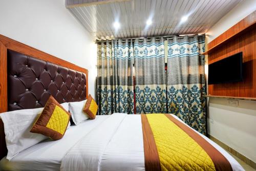 a bedroom with a large bed and a television at Hotel Preet - Family Hotel in New Delhi