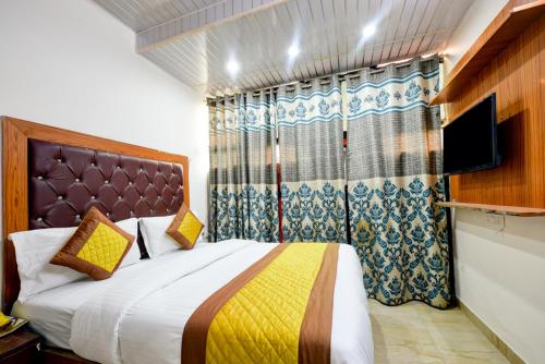 a bedroom with a large bed and a television at Hotel Preet - Family Hotel in New Delhi