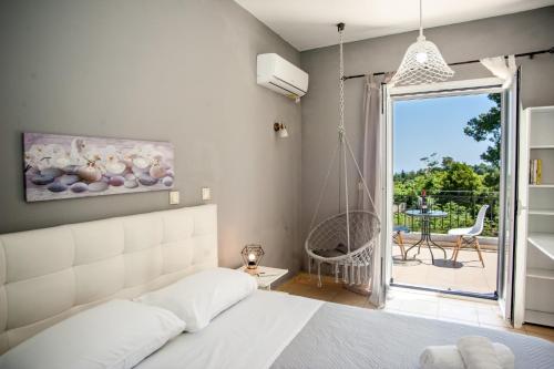 a bedroom with a bed and a balcony with a swing at Gravanis IR Home in Pesádha