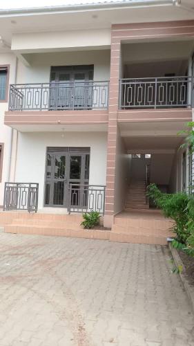 a large building with a balcony and a staircase at Kasha's Hideout 1 Namugongo Sonde in Mukono