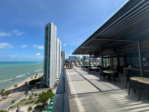 a building with tables and chairs on a balcony overlooking the beach at Park Hotel in Recife