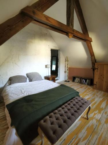 ein großes Schlafzimmer mit einem großen Bett im Dachgeschoss in der Unterkunft Chambre d'hôtes EPI in Ingrandes