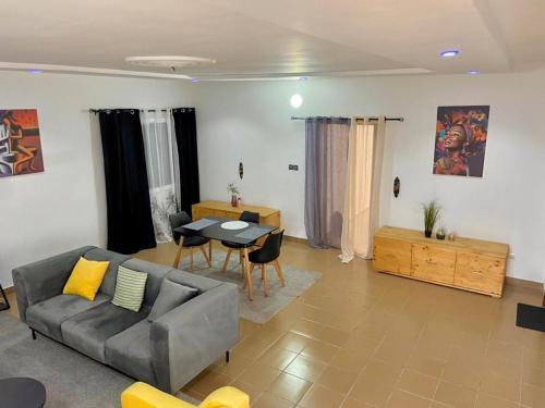 uma sala de estar com um sofá e uma mesa em Luxe minontin em Cotonou