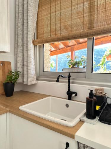 a white sink in a kitchen with a window at Anerada Cottages in Apsiou