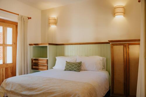 a bedroom with a white bed and two lights at Hotel La Corada in Villa de Leyva
