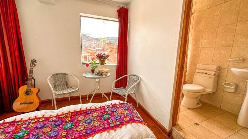 a bedroom with a bed and a sink and a guitar at Apart Hotel de Alegria in Cusco
