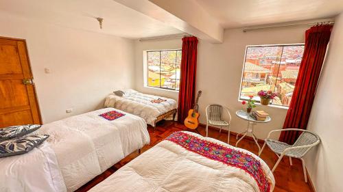 a bedroom with two beds and a window at Apart Hotel de Alegria in Cusco
