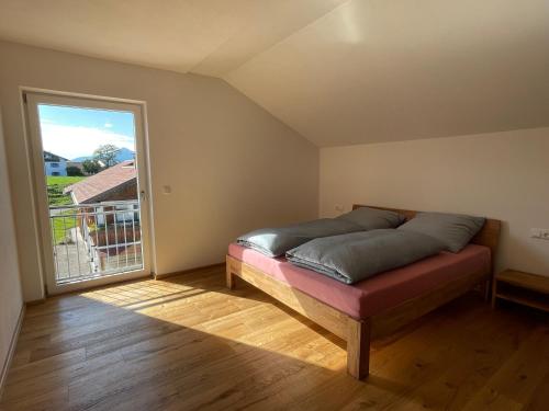 a bedroom with a bed and a large window at AllgäuBlick - Ferienwohnung mit Bergblick - Königscard in Hopferau