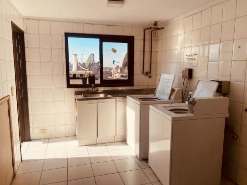 una cocina con electrodomésticos blancos y una ventana en GRAMAR en Mendoza