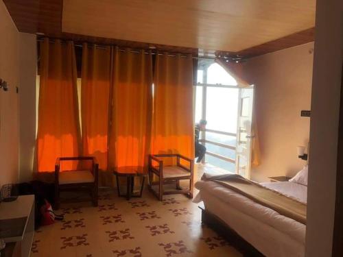 um quarto com cortinas cor de laranja, uma cama e uma janela em SalberrybyJJR em Lansdowne