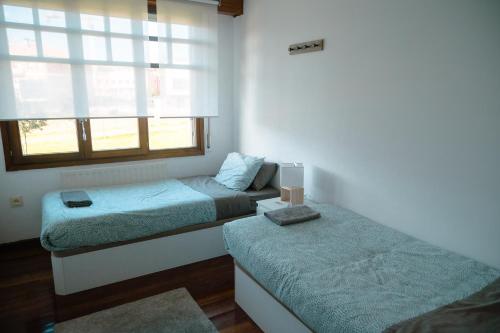 a room with two beds and a window at Chalet Bilbao-Aeropuerto in Sondika