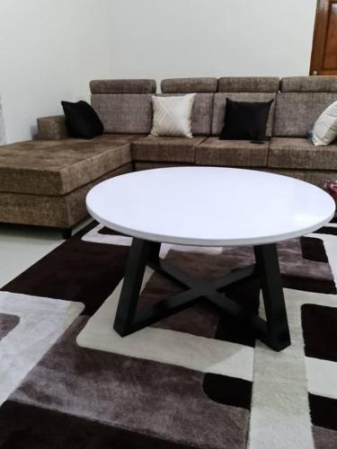 a white table in a living room with a couch at Kasha's Hideout 1 Namugongo Sonde in Mukono